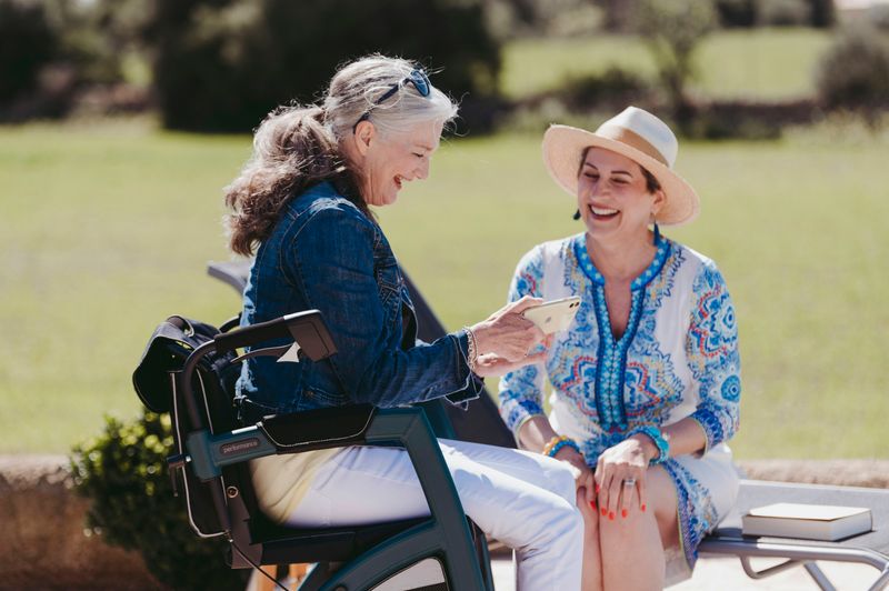 Older woman with phone next to younger woman.