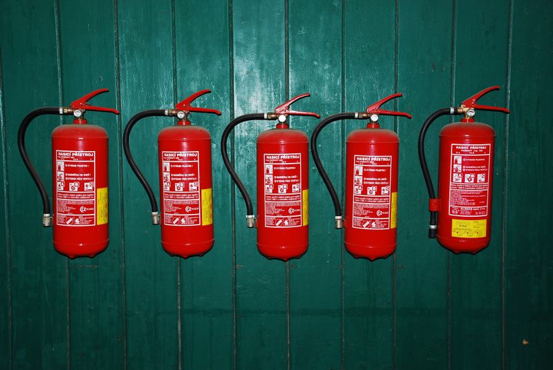 Five fire extinguishers on a wall.