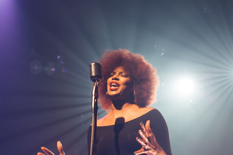 Photo of a woman singing into a microphone 