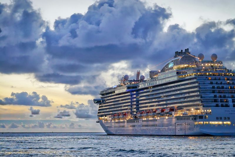 cruise ship in the water at sun down with the lights on