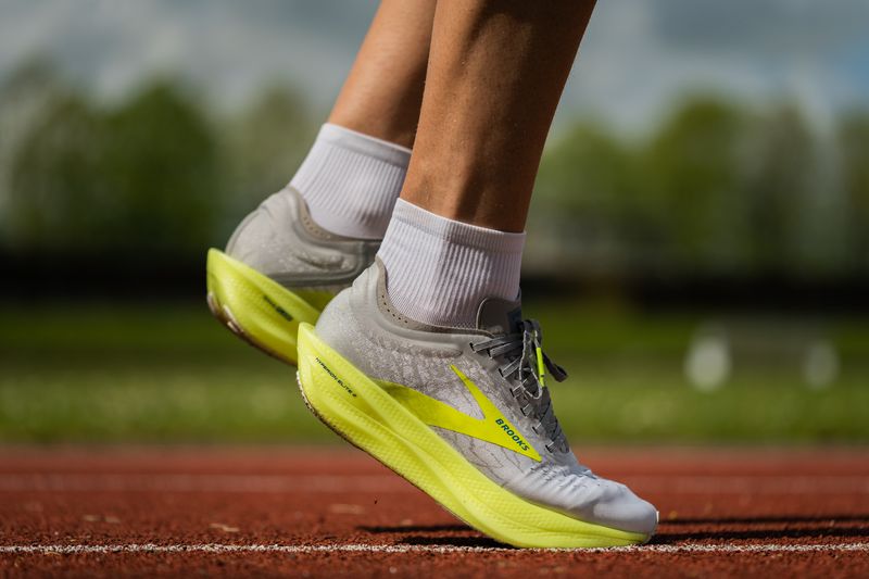 closeup image of an athlete's shoes and socks on a track field.