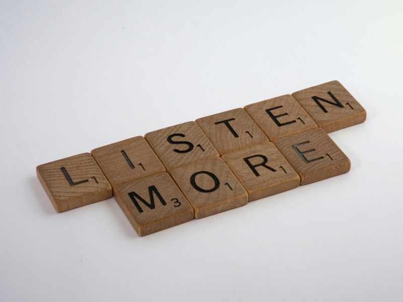 Scrabble letter that spell out the words 'Listen More'