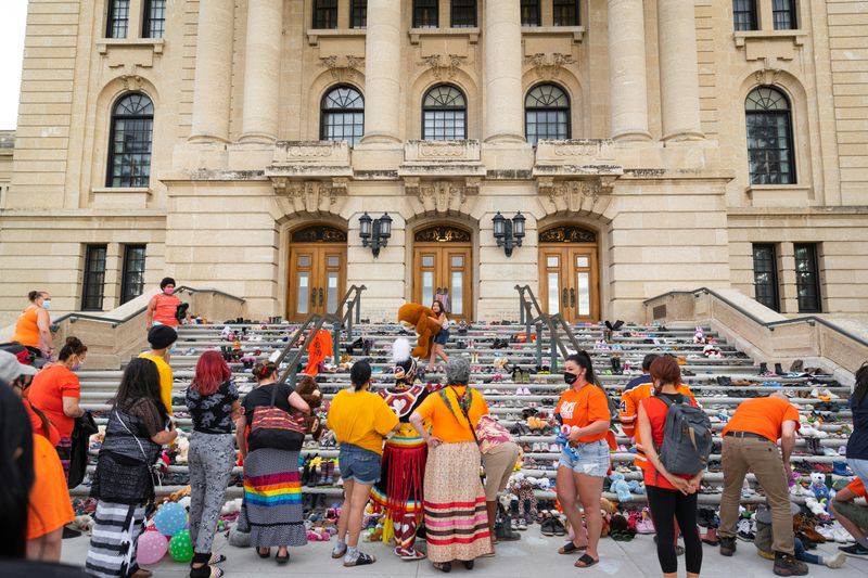 First Nations people participating in traditional cultural ceremonies and celebrations at government building..