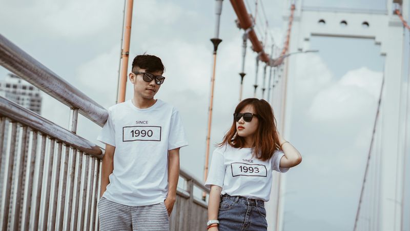 A couple walking across a bridge using body language to communicate.