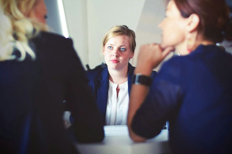 A woman being interviewed by two people.