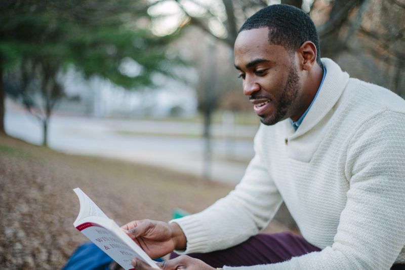 A person in a field reviewing an investment guide