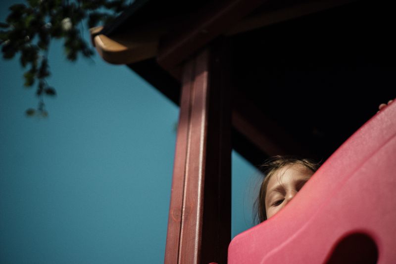 An image a child peeking over the edge of a structure.