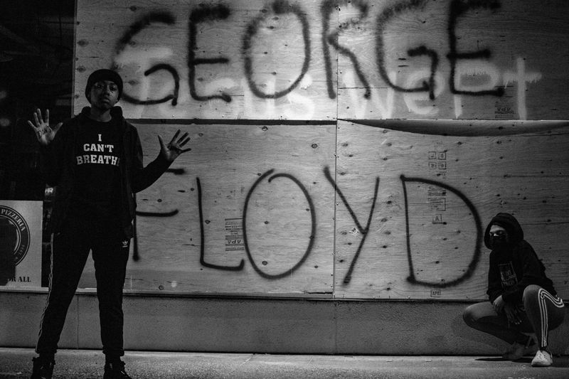 Protestors in front of graffiti that says 