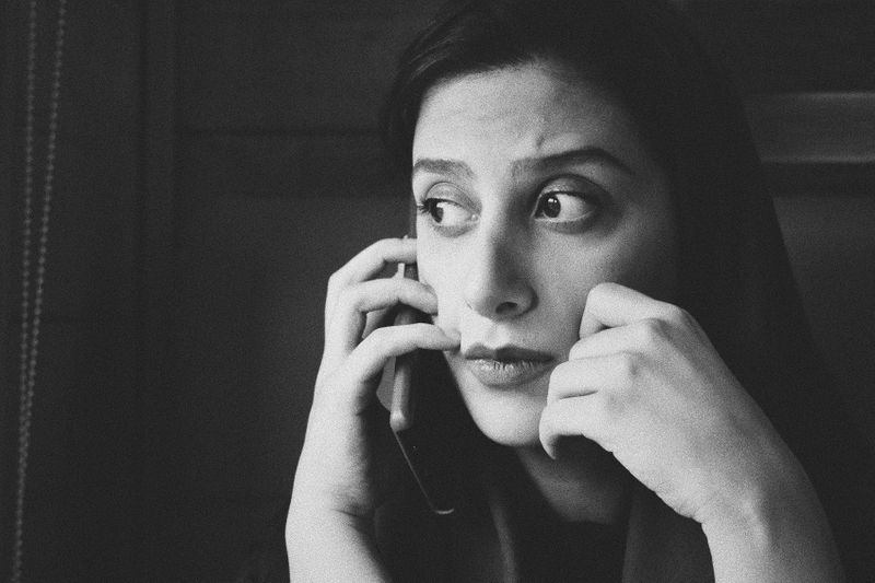 A woman on her cell phone looking worried.