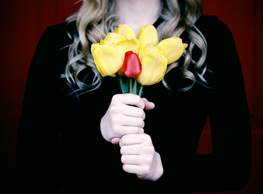 A person holding up a bouquet of flowers.
