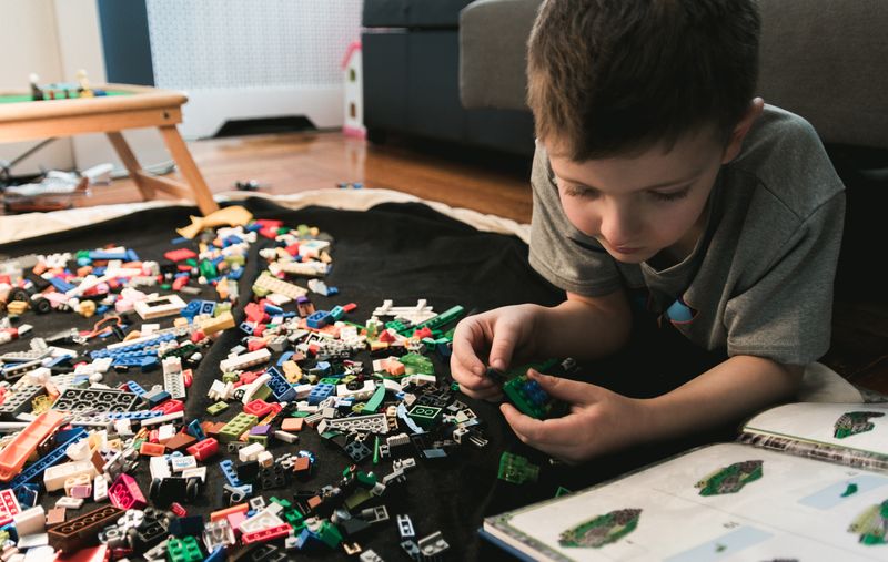Child thinking what he should build with Legos