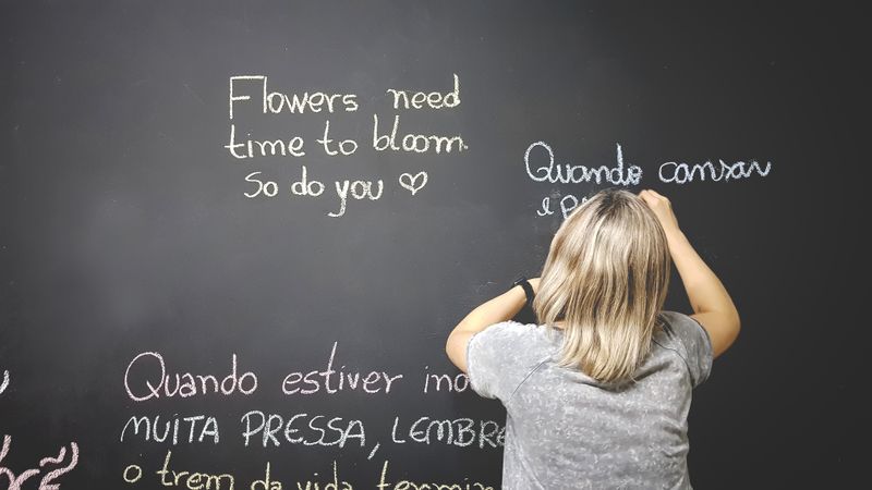 A teacher writing on a blackboard in different languages. 