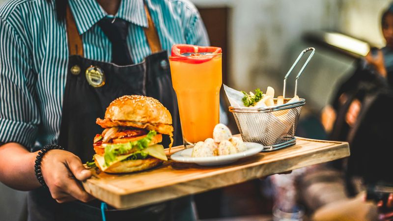 A server holding a tray of pub food.