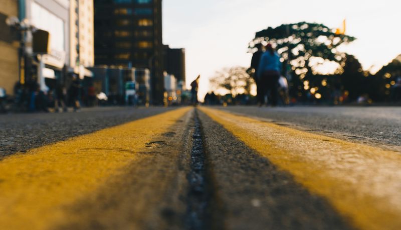 A set of painted road lines vanishing into a horizon point.