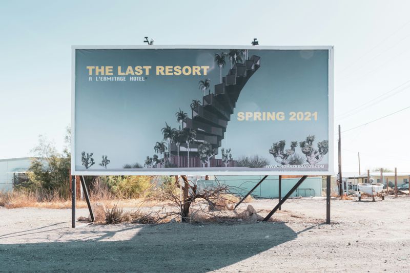 A small billboard advertising a resort in the desert.