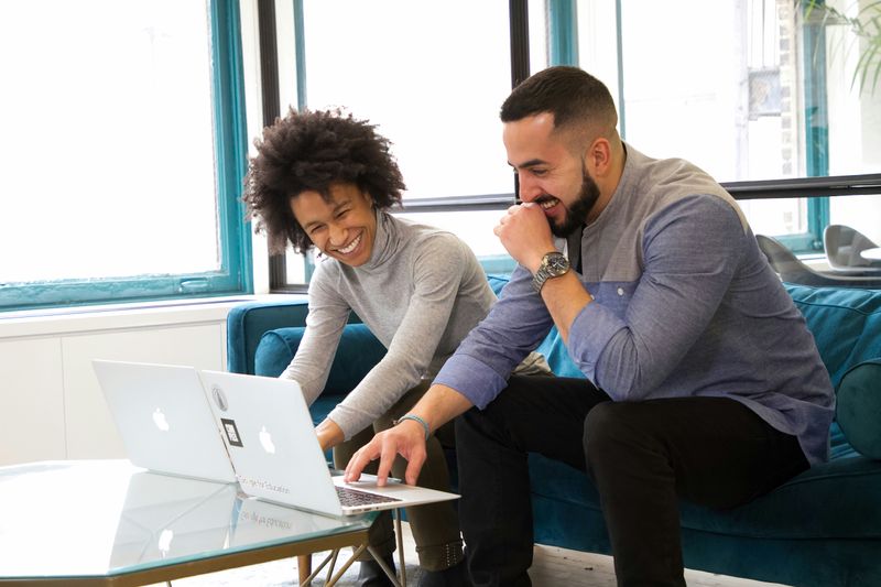 A man and woman working on a project in an office.