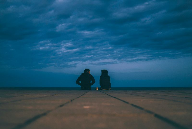 Two people sitting on a path discussing a boundary in their relationship.