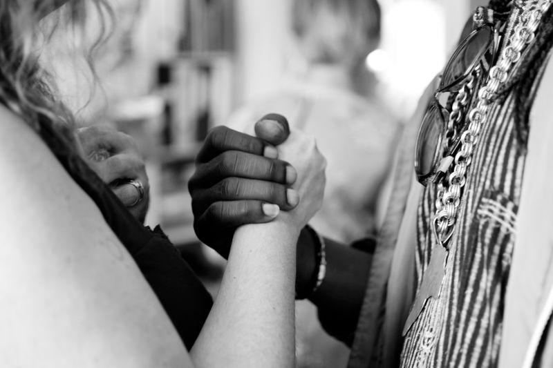 A Black person and White person holding hands