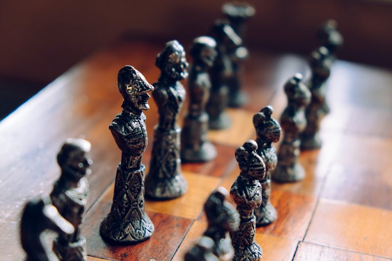 An old chessboard with human-like characters as pieces.