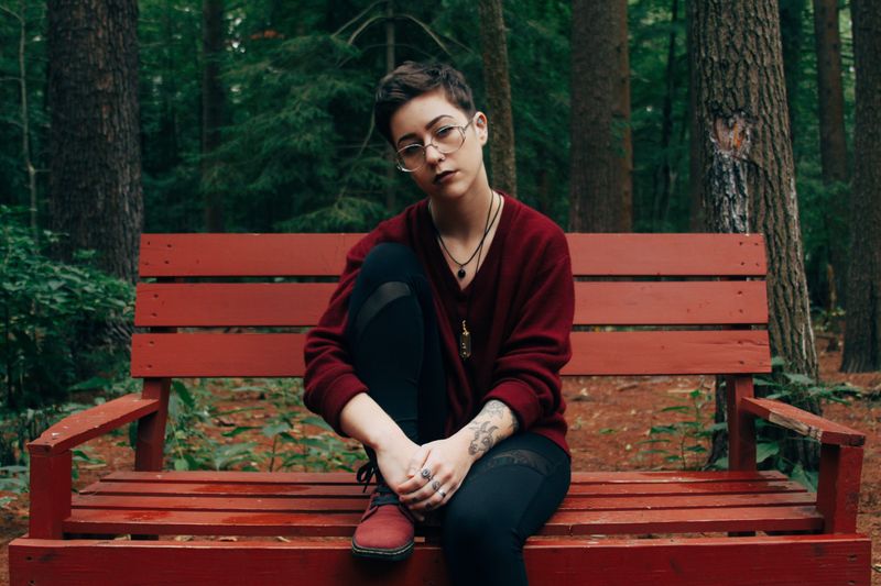 A person on a bench in a forest.