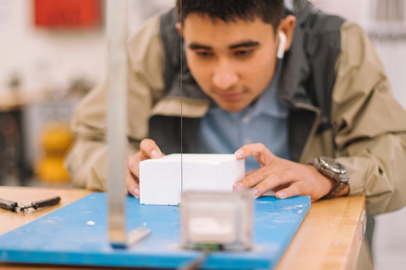 Close up image of a young man doing some experiment in a lab setting.