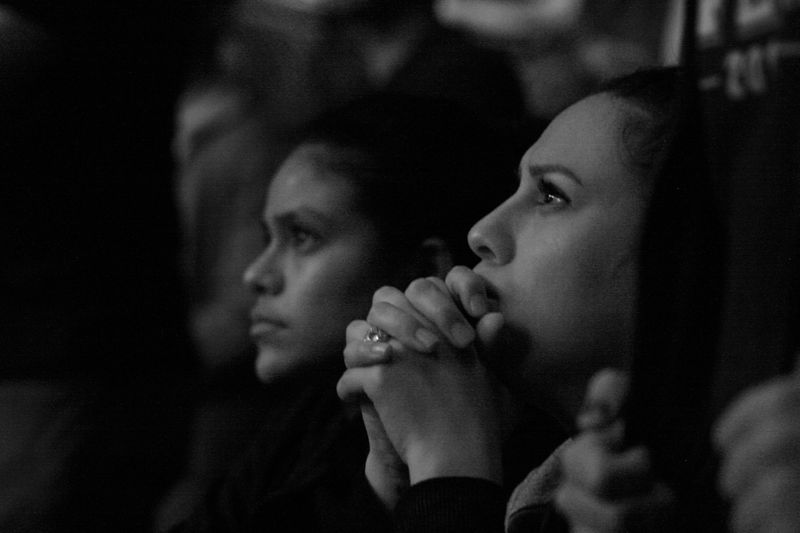 Two women listening intently to a lecture or presentation. 