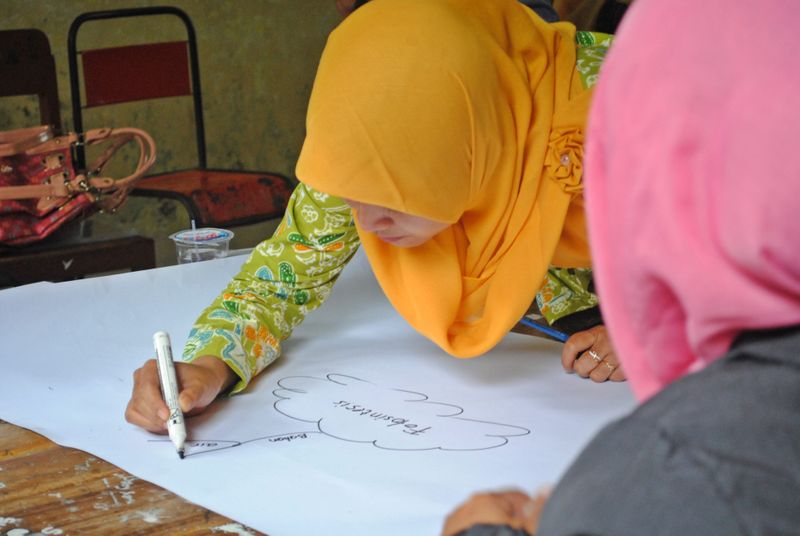 A woman using the mind mapping note taking method in a classroom.