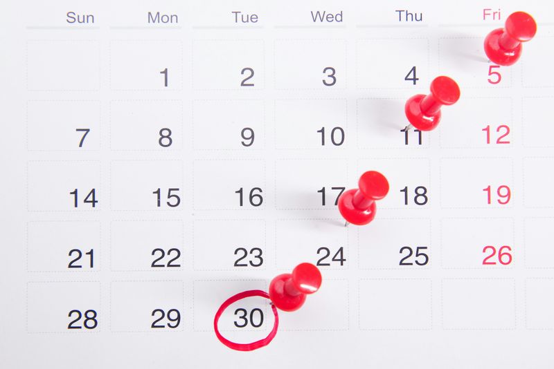 A calendar with pins marking four dates.