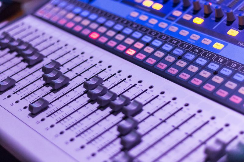 Photo of a sound engineer's electronic keyboard in colors of lilac and blue hues with some control switches in yellow tones