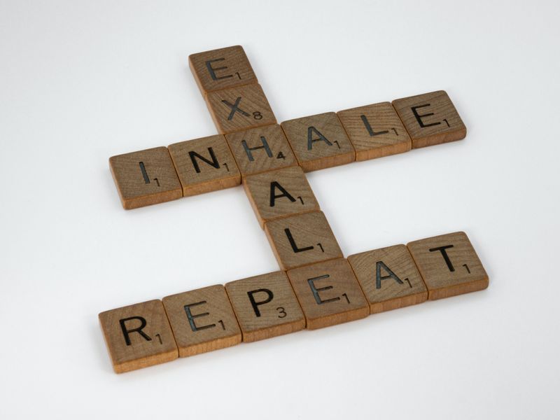 Scrabble tiles spell out the words exhale, inhale, repeat. 