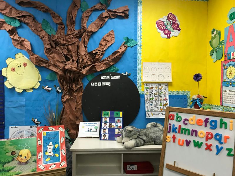 A classroom in an elementary school with colorful art on the walls.