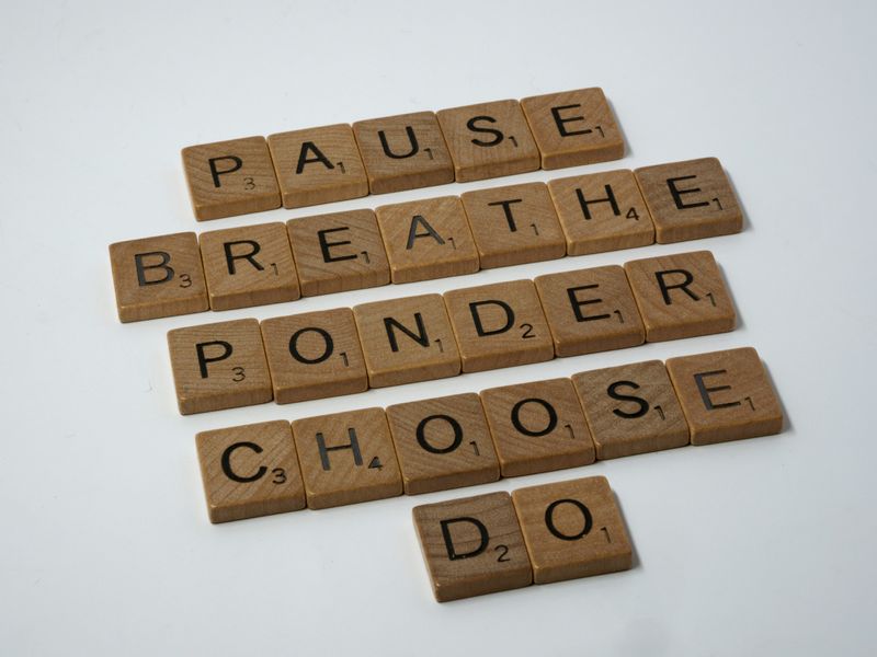 Scrabble pieces spelling out the words pause, breathe, ponder, choose and do.