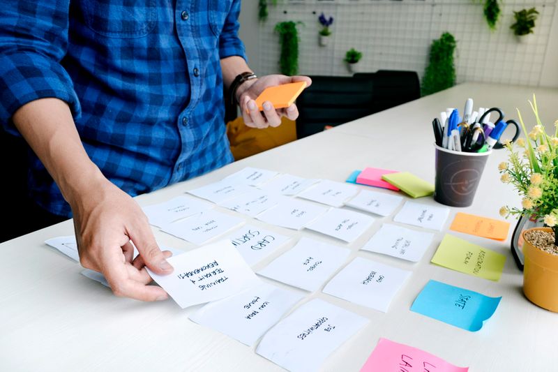 A man sorting sticky notes into different categories. 