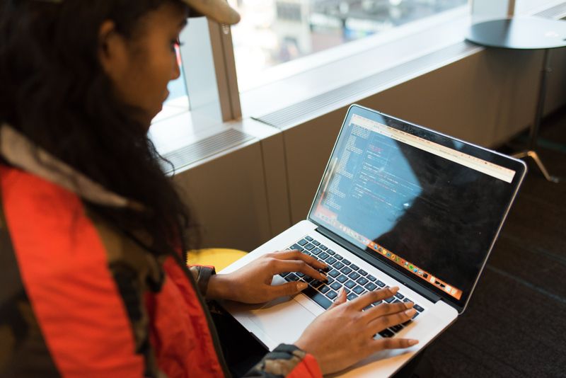 Image: Person coding on a laptop in an office building