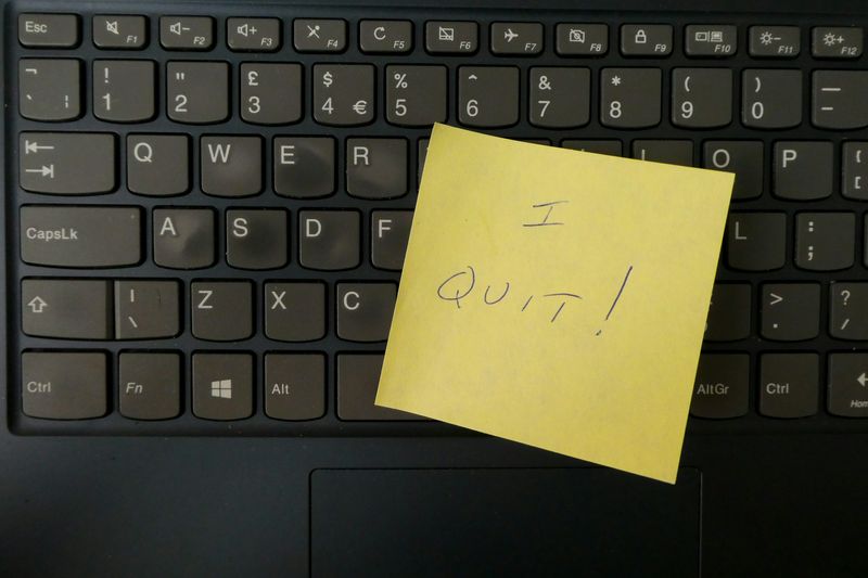 A computer keyboard with a yellow sticky note on it that says, 