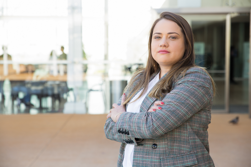 A young businesswoman standing confidently with her arms crossed.