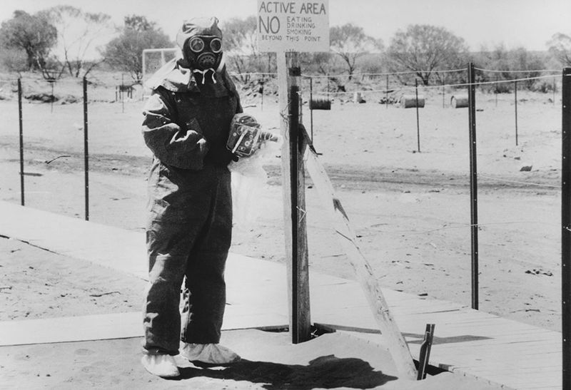 An Australian nuclear scientist in a hazmat suit at a testing site.