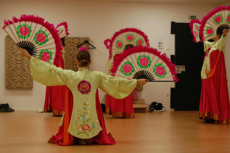 Women in traditional Korean attire performing the fan dance.