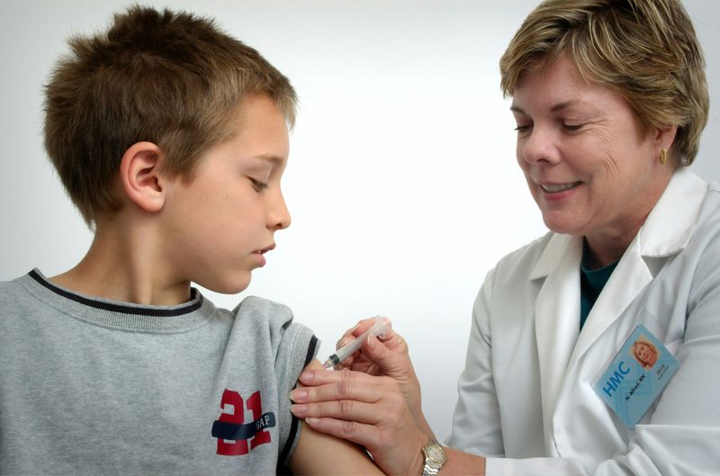 A pediatrician holding a smiling baby during a check-up.