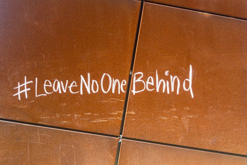 On the wall, there is a tag saying 'Leave No One Behind'.