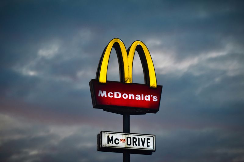 McDonald's golden arch logo with a sign underneath for the drive-through.