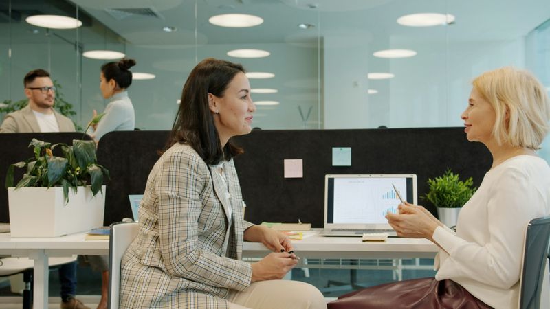 Employees in an open-concept office, chatting with each other in different groups.