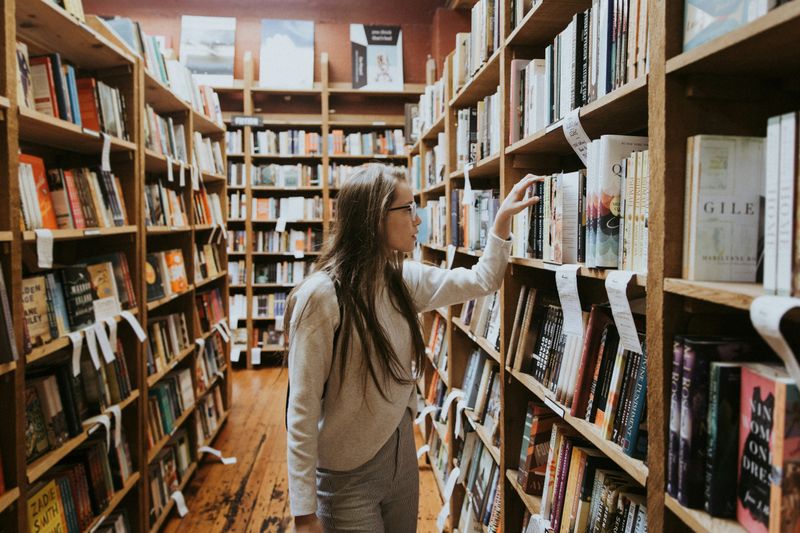 Woman searching for a book at a bookshop. 
