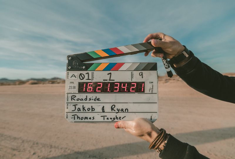 Person's arms holding a director's clapboard