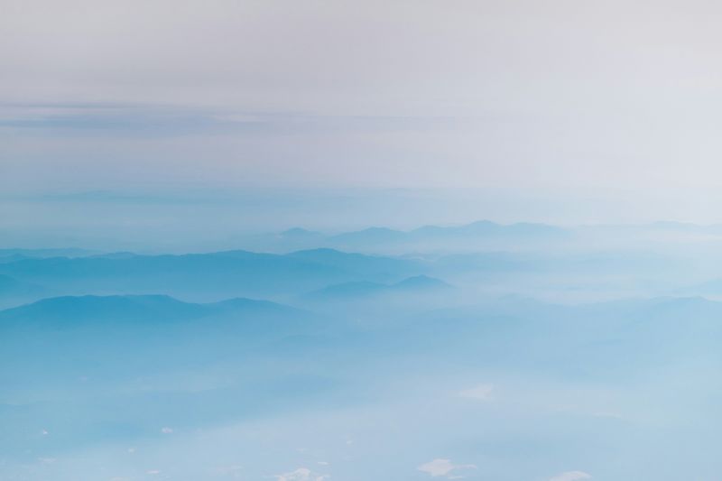 A mountain landscape photographed with a soft blue hue.