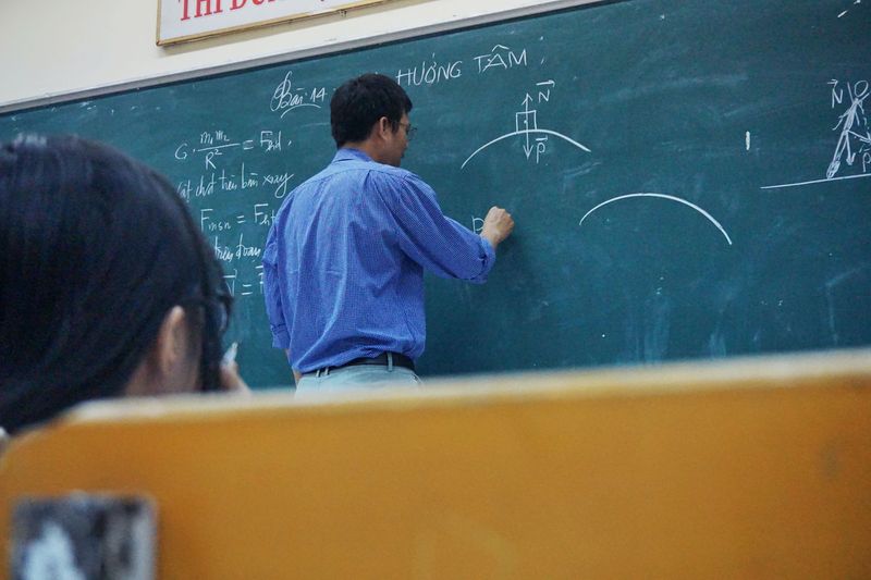 Professor writing on a chalkboard.