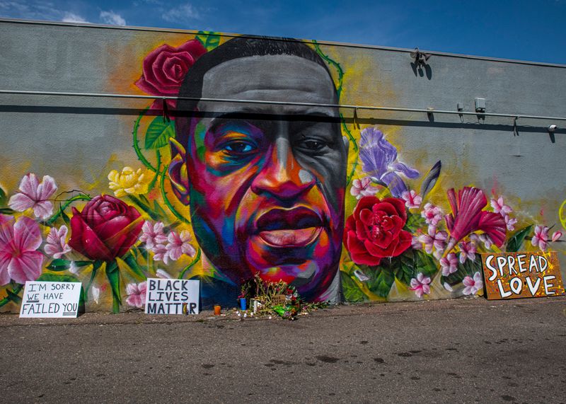 Colorful mural of George Floyd and flowers on the side of a building.