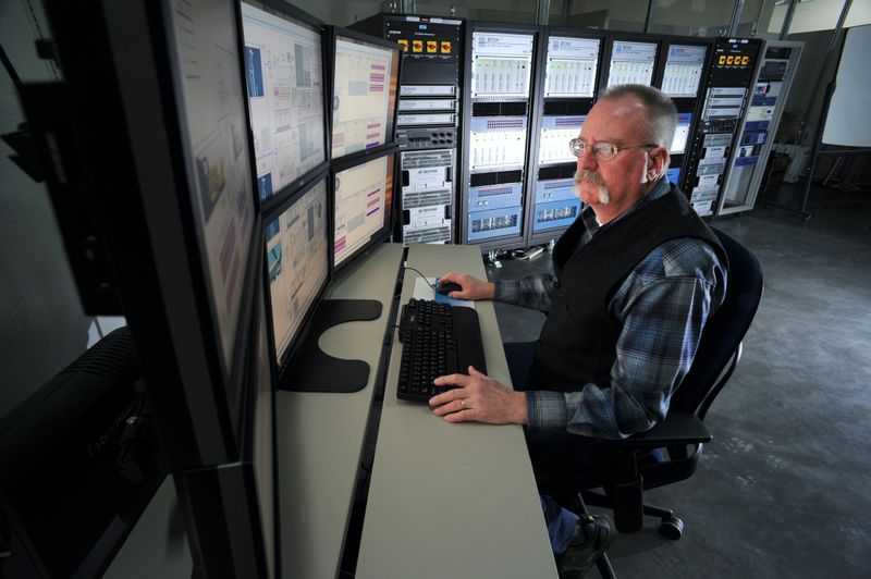 a database manager working at a computer with many monitors