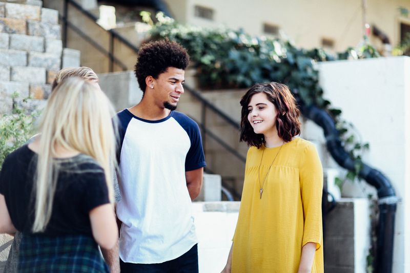 Three friends are communicating with each other in an open space.