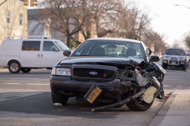 Black Ford with collision damage on the front left side of the car.